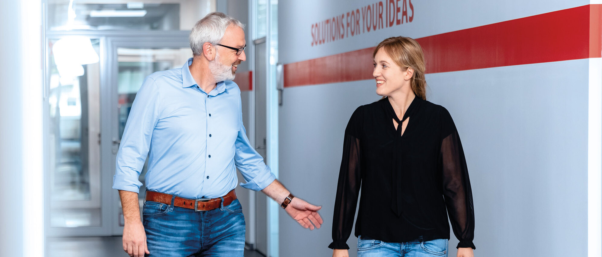 Zwei Mitarbeitende besprechen sich im Flur