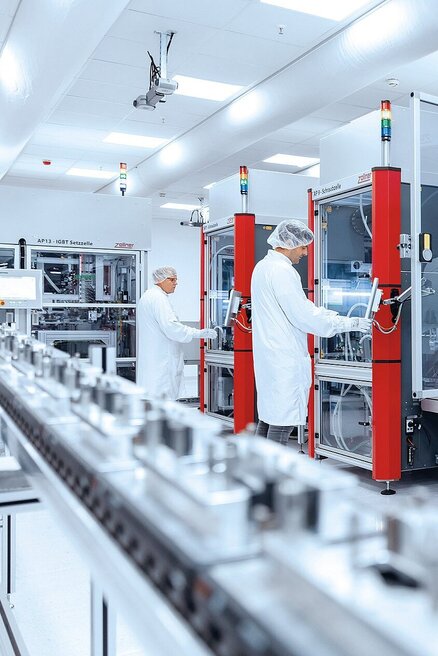 Mitarbeiter an einer Montagelinie in Automotive in der Sauberraumumgebung 