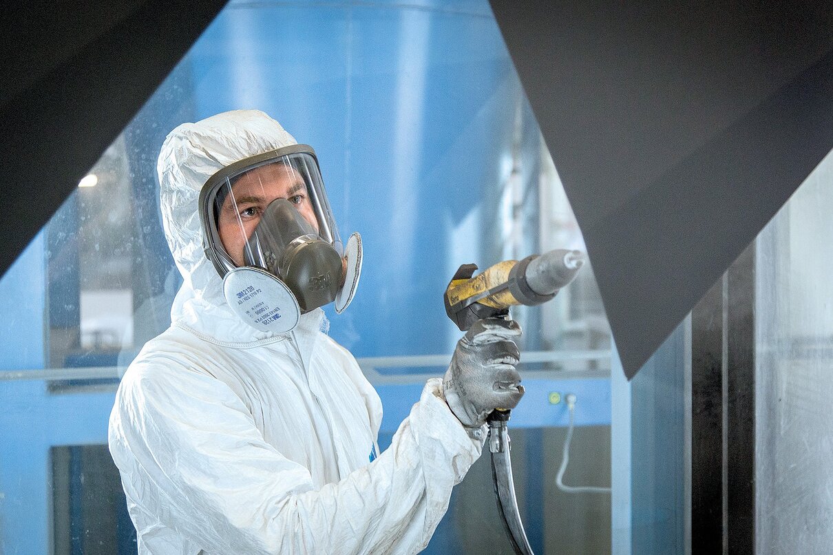 Pulverbeschichten durch einen Mitarbeiter in der Produktion 