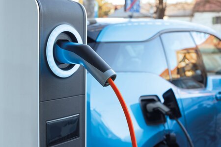Elektroauto wird an einer Ladestation mit angeschlossenem Ladekabel geladen.