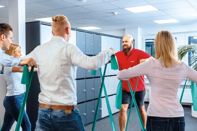 Mitarbeiter der Zollner Elektronik AG machen Übungen zur betrieblichen Gesundheitsförderung im Büro.
