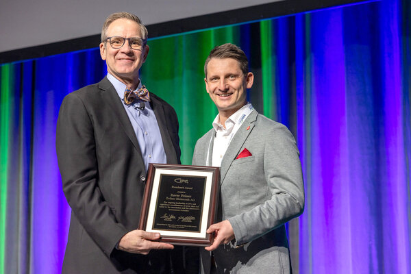 Franz Xaver Feiner (Zollner Elektronik AG) wird vom IPC Moderator mit dem IPC President´s Award ausgezeichnet und hält die Ehrenurkunde in den Händen 
