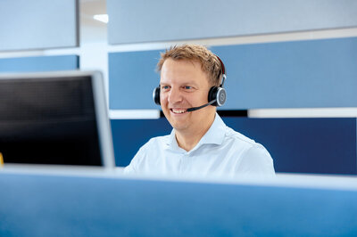 Mitarbeiter der Zollner Elektronik AG mit Headset beim digitalen Lernen am Computer.