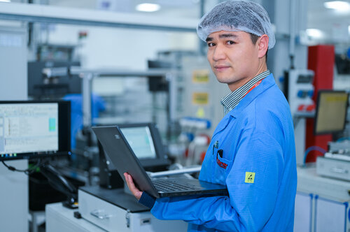 Produktionsmitarbeiter in China bedient eine Maschine