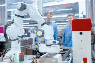 Kollaborierender Industrieroboter montiert Bauteile in automatisierter Fertigungslinie, Konzept Design for automated Assembly.