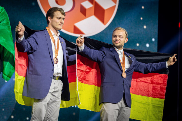 Zwei Mitarbeiter der Zollner Elektronik AG mit deutscher Flagge und Bronzemedaillen bei EuroSkills 2025