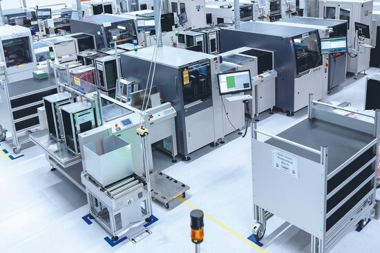 Moderne Fertigungslinie für Flachbaugruppen mit automatisierten SMT- und THT-Anlagen.