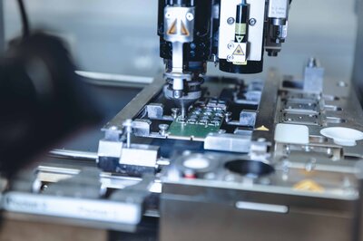 Fertigungsmaschine bearbeitet elektronische Baugruppe im Rahmen Design for Sustainability.