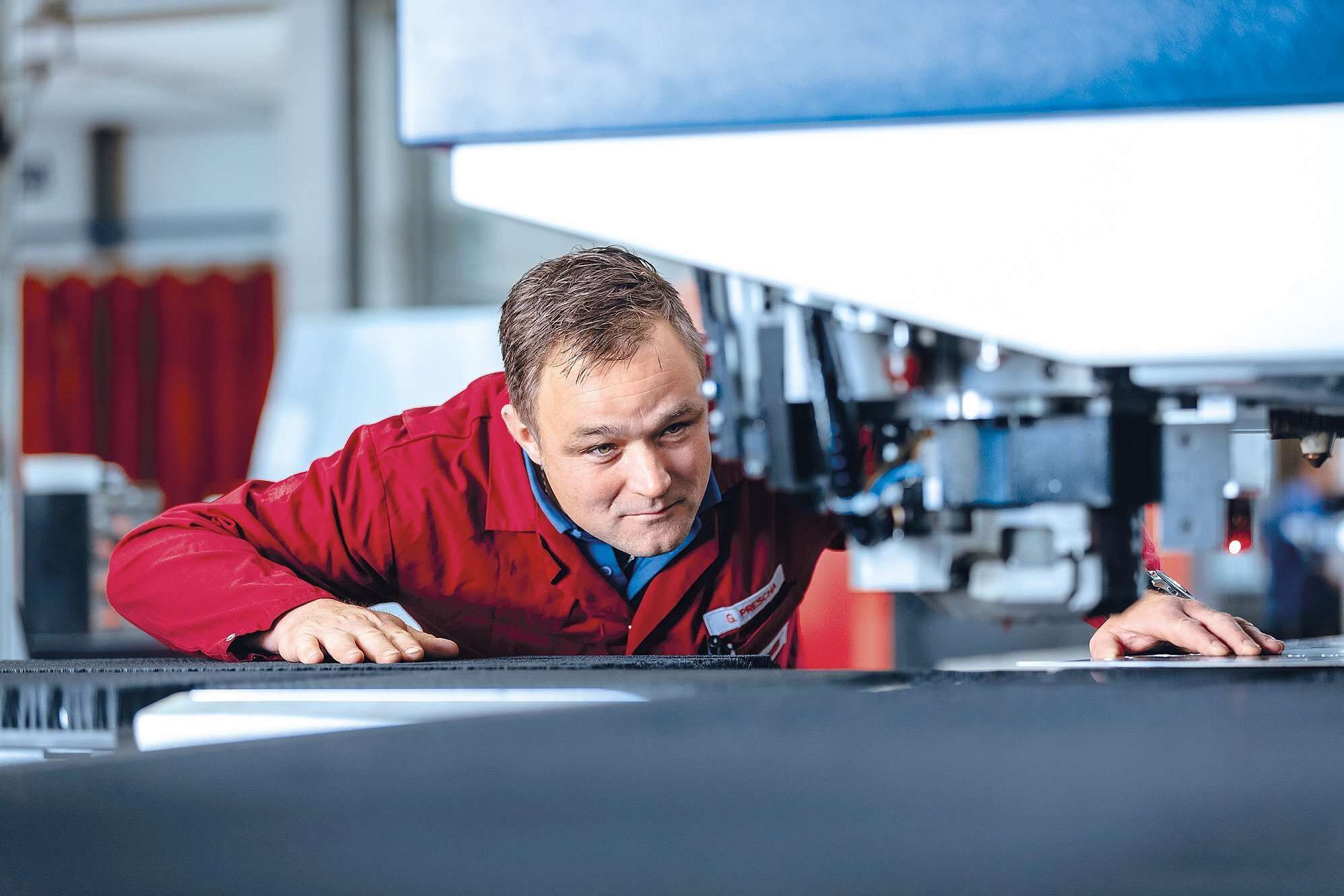 Mitarbeiter der Zollner Elektronik AG arbeitet an einer mechanischen Fertigungsmaschine für Blech-, Dreh- und Frästeile in der Produktion.
