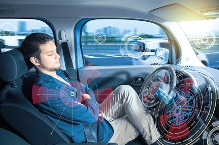 Person sitzt entspannt in autonom fahrendem Auto mit digitalen Sensoranzeigen.