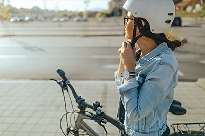 Mitarbeiter der Zollner Elektronik AG steht mit Fahrrad und trägt Helm, Hinweis auf Rundumschutz beim Fahrradleasing.